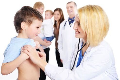 médico examina un neno con vermes